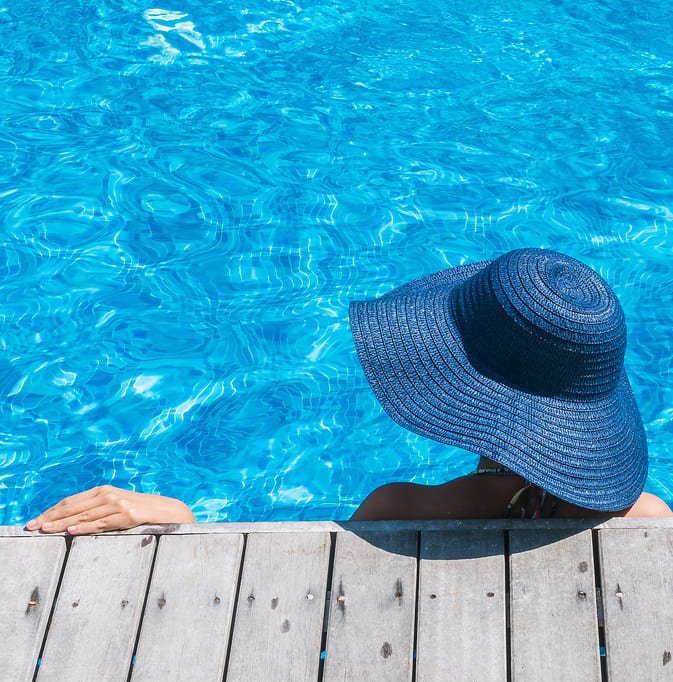 Mulher com chapéu na piscina